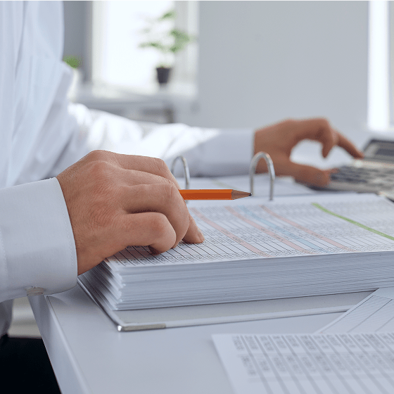 Bookkeeper reviewing financial records and calculating totals.
