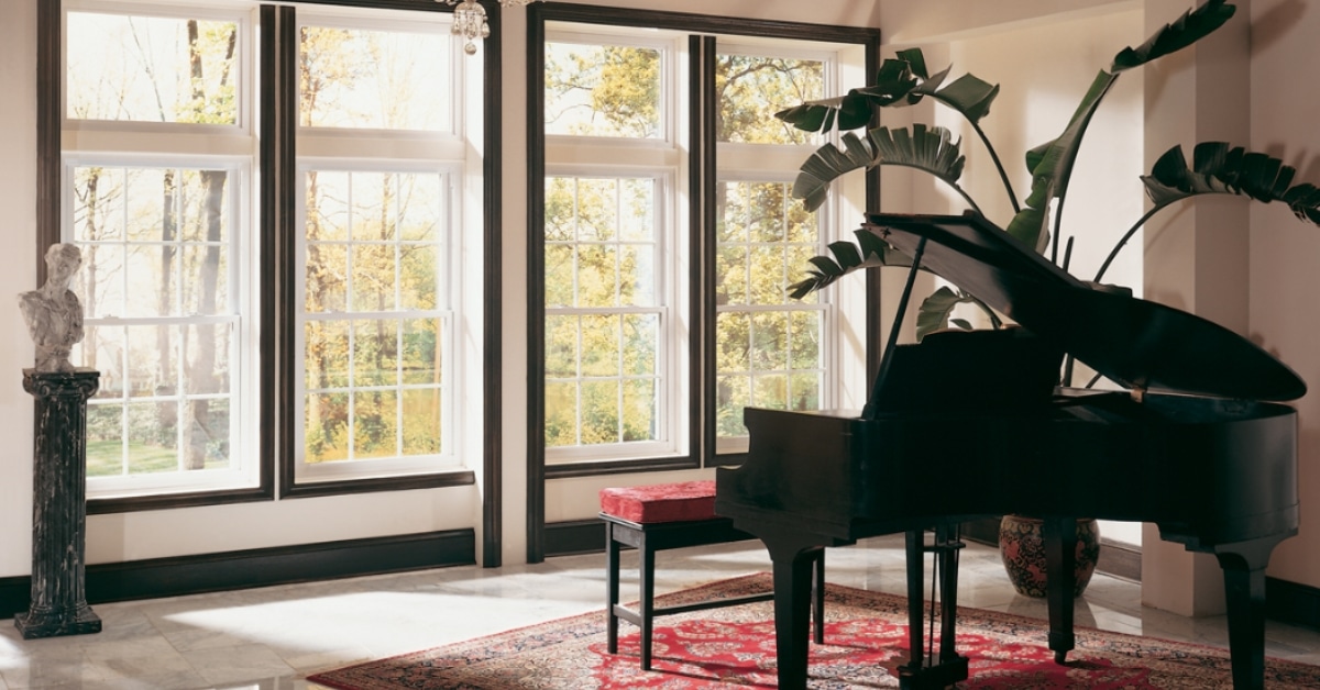 Triple vertical double-hung windows featuring traditional grids and dark wood trim