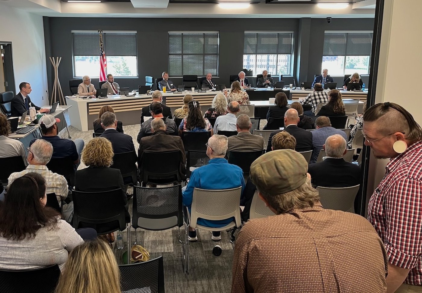A crowd spills out of a meeting room at the Thyra Thomson State Office Building in Casper, Wyo., July 2025, in anticipation of a nuclear waste storage discussion. (Dustin Bleizeffer/WyoFile via AP)