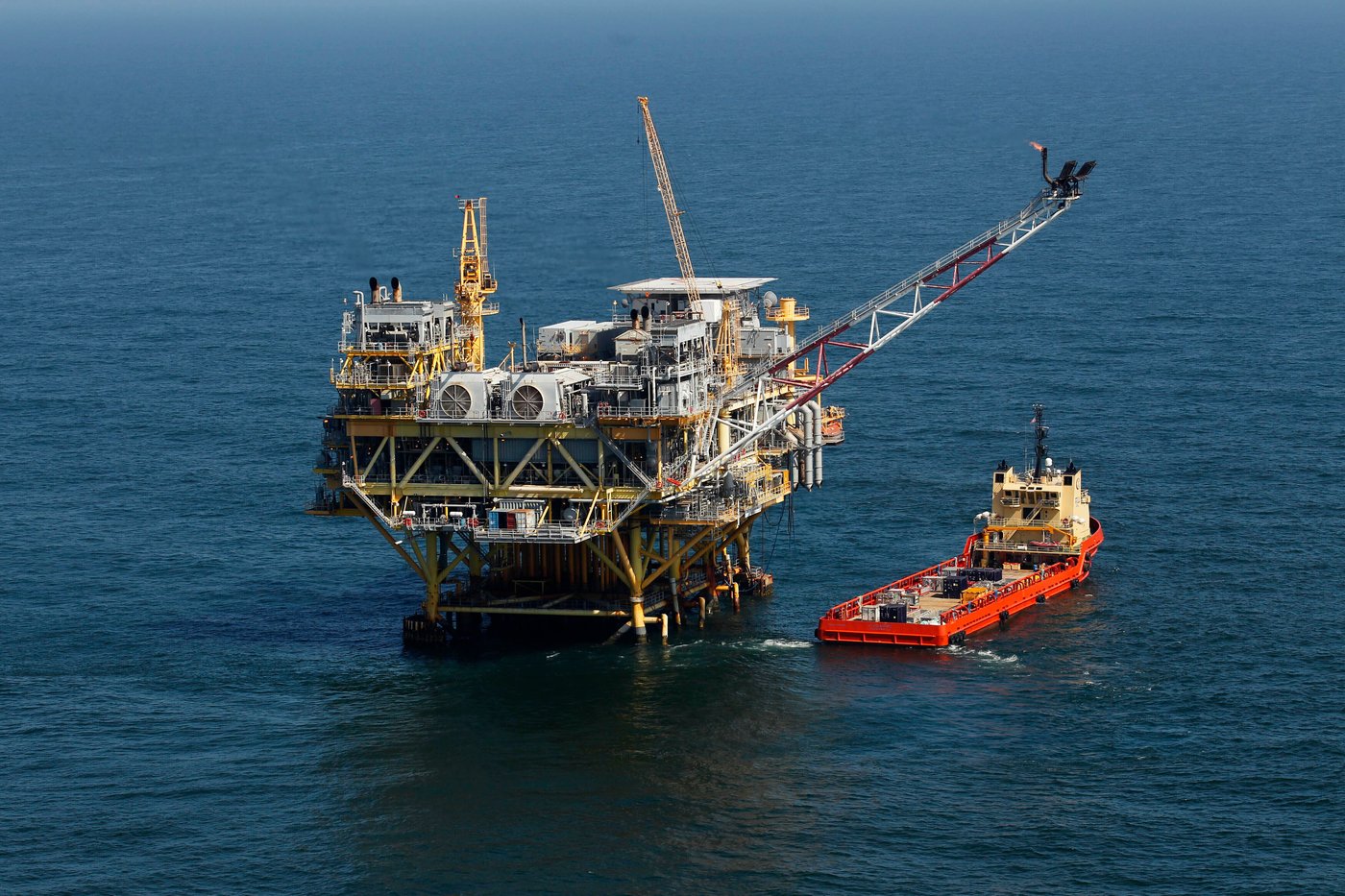 FILE - A supply vessel boat sits near an oil rig in the Gulf of Mexico, off the coast of Louisiana. April 10, 2011. (AP Photo/Gerald Herbert, File)
