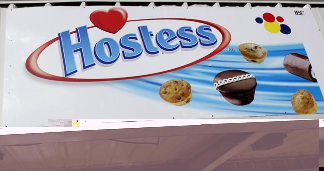 FILE - A Hostess sign is shown on a closed retail outlet store in Garland, Texas, Jan. 11, 2012. Hostess, the maker of snack classics like Twinkies and HoHos, is being sold to J.M. Smucker in a cash-and-stock deal worth about $5.6 billion. Smucker, which makes everything from coffee to peanut butter and jelly, will pay $34.25 per share in cash and stock, and it will also pick up approximately $900 million in net debt. (AP Photo/LM Otero, file)