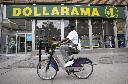 A person cycles past a Dollarama store in Montreal, Wednesday, June 7, 2023. THE CANADIAN PRESS/Christinne Muschi