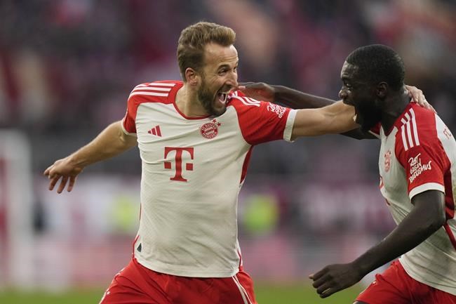 Bayern's Harry Kane, left, celebrates with his teammate Serge Gnabry after scoring his side's second goal during the German Bundesliga soccer match between Bayern Munich and Heidenheim at the Allianz Arena stadium in Munich, Germany, Saturday, Nov. 11, 2023. (AP Photo/Matthias Schrader)