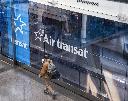 A traveller walks past an Air Transat logo in departures at Montreal-Pierre Elliott Trudeau International Airport in Montreal on Tuesday, Dec. 9, 2025. THE CANADIAN PRESS/Christinne Muschi