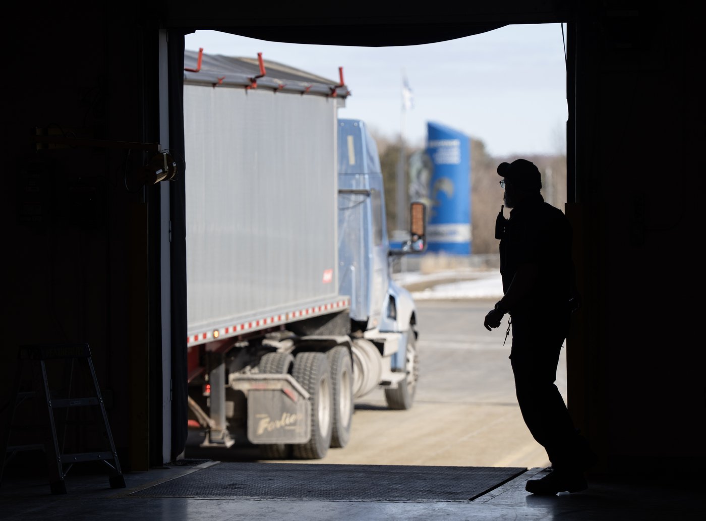 A Canada Border Services officer looks over at a truck as it waits to be inspected at the Highway 55 Port of Entry in Stanstead, Que., Thursday, March 13, 2025. THE CANADIAN PRESS/Christinne Muschi