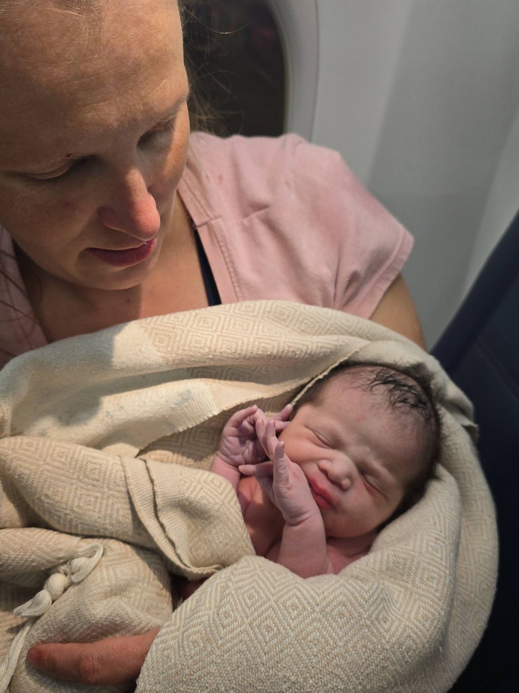 In this photo provided by Tina Fritz, Ashley Blair holds her daughter Brielle, who was born April 24, 2026, on a Delta Air Lines flight just as it was landing in Portland, Ore. (Tina Fritz via AP)