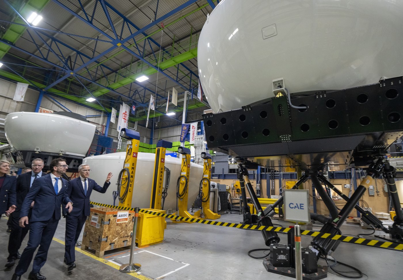 CAE Inc. chief executive Matthew Bromberg, left, and Prime Minister Mark Carney tour company facilities in Montreal, on Tuesday, Feb. 17, 2026. THE CANADIAN PRESS/Christinne Muschi