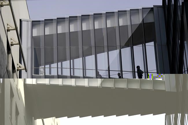 People walk in a bridge connecting buildings at Twitter headquarters in San Francisco, Friday, Oct. 28, 2022. (AP Photo/Jeff Chiu)