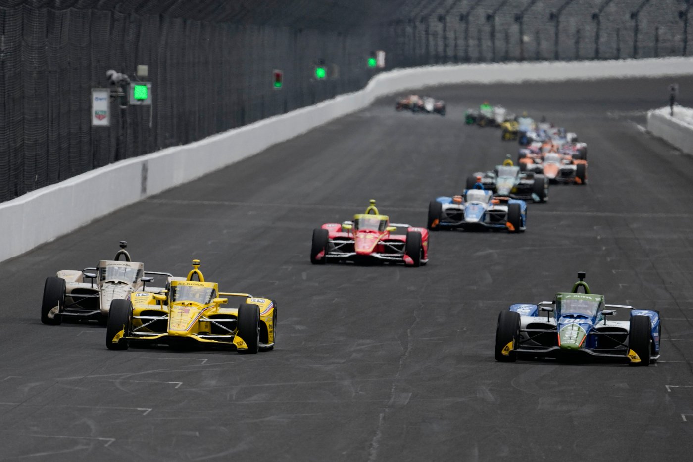 Scott McLaughlin (3) and Helio Castroneves, of Brazil, head into the first turn during practice for the Indianapolis 500 auto race at the Indianapolis Motor Speedway in Indianapolis, Monday, May 18, 2026. (AP Photo/Michael Conroy)