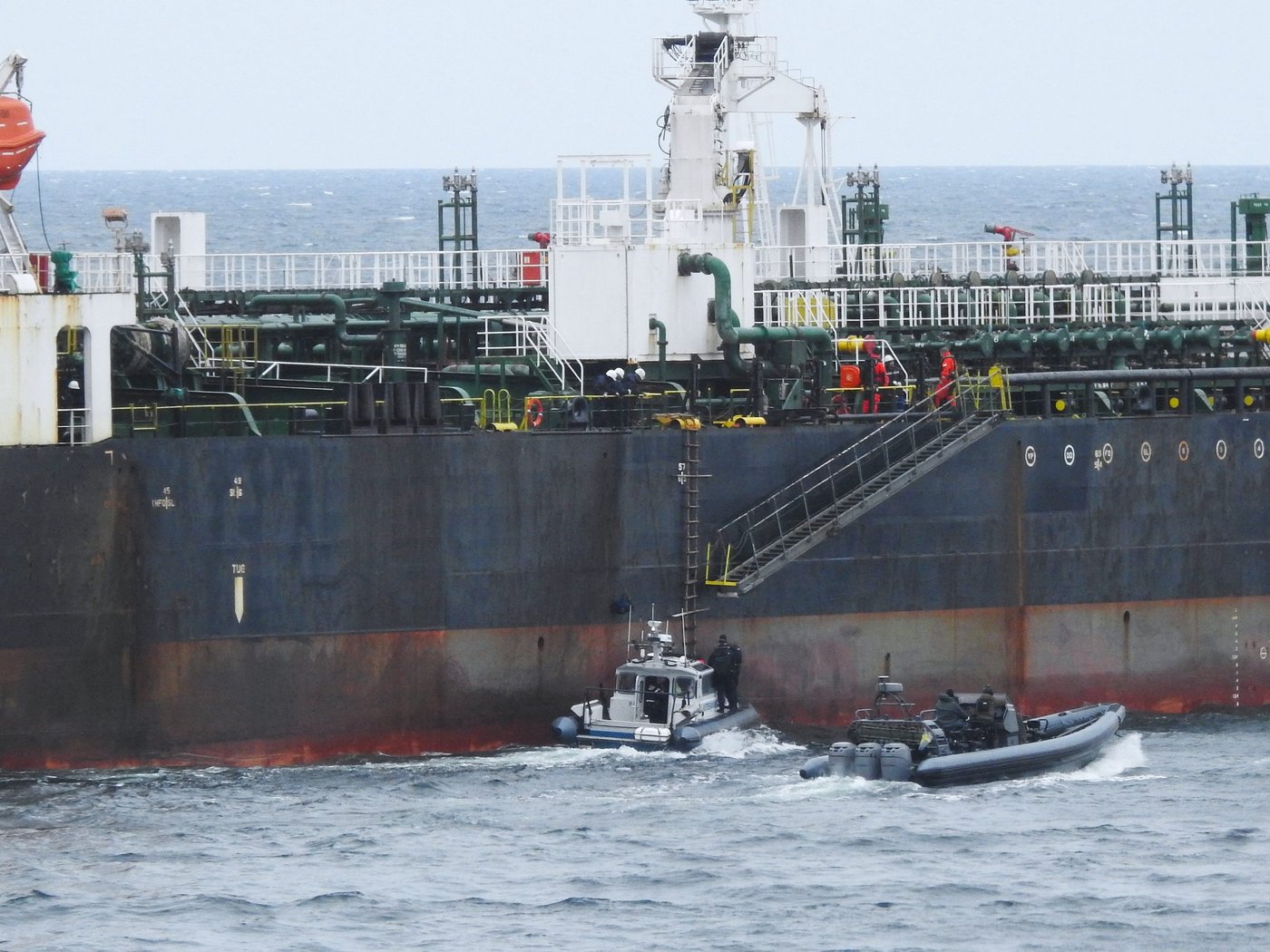 In this photo provided by the Swedish Coast Guard, personnel board a tanker suspected of causing an oil spill in the Baltic Sea, Friday, April 3, 2026. (Swedish Coast Guard via AP)