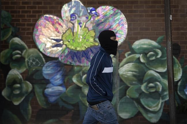 A pedestrian wears a balaclava ski mask to shield from the cold air along Columbus Boulevard in Philadelphia, on Monday, Jan. 11, 2021. (Jose F. Moreno/The Philadelphia Inquirer via AP)