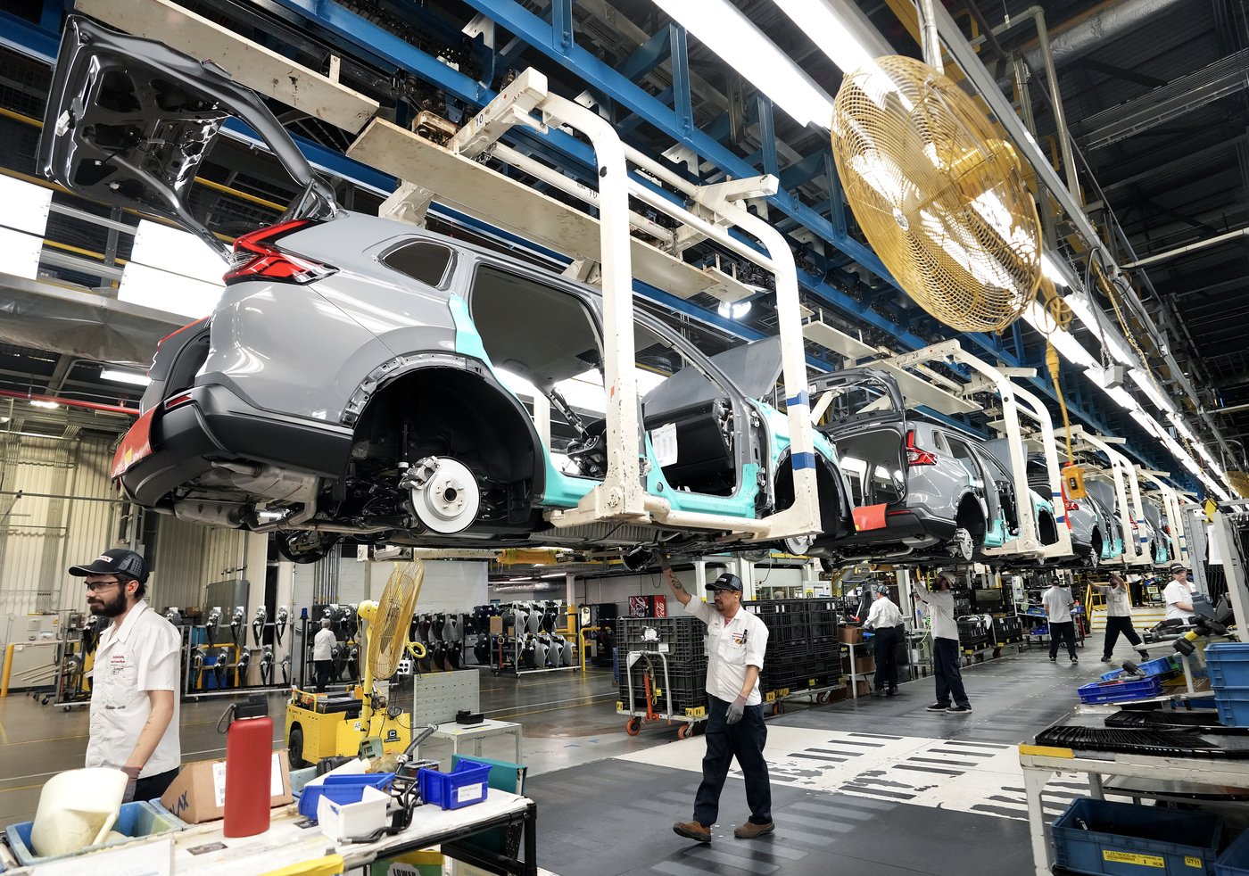 Honda employees work along the vehicle assembly line before an event announcing plans for a Honda electric vehicle battery plant in Alliston, Ont., on Thursday, April 25, 2024. THE CANADIAN PRESS/Nathan Denette