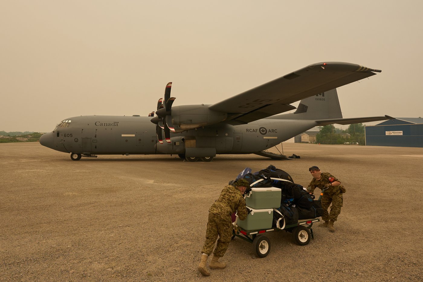 File photo — Royal Canadian Air Force crew help load cargo as evacuees board a C-130 Hercules aircraft in Norway House, Man., Tuesday, June 3, 2025. THE CANADIAN PRESS/David Lipnowski