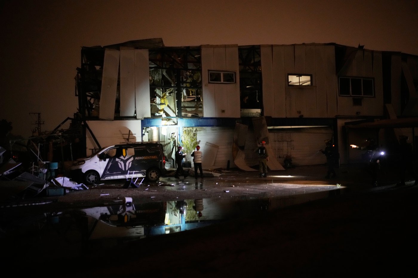 Israeli security forces and rescue teams inspect a site struck by an Iranian missile in Petah Tikva, Israel,Thursday, April 2, 2026. (AP Photo/Ohad Zwigenberg)
