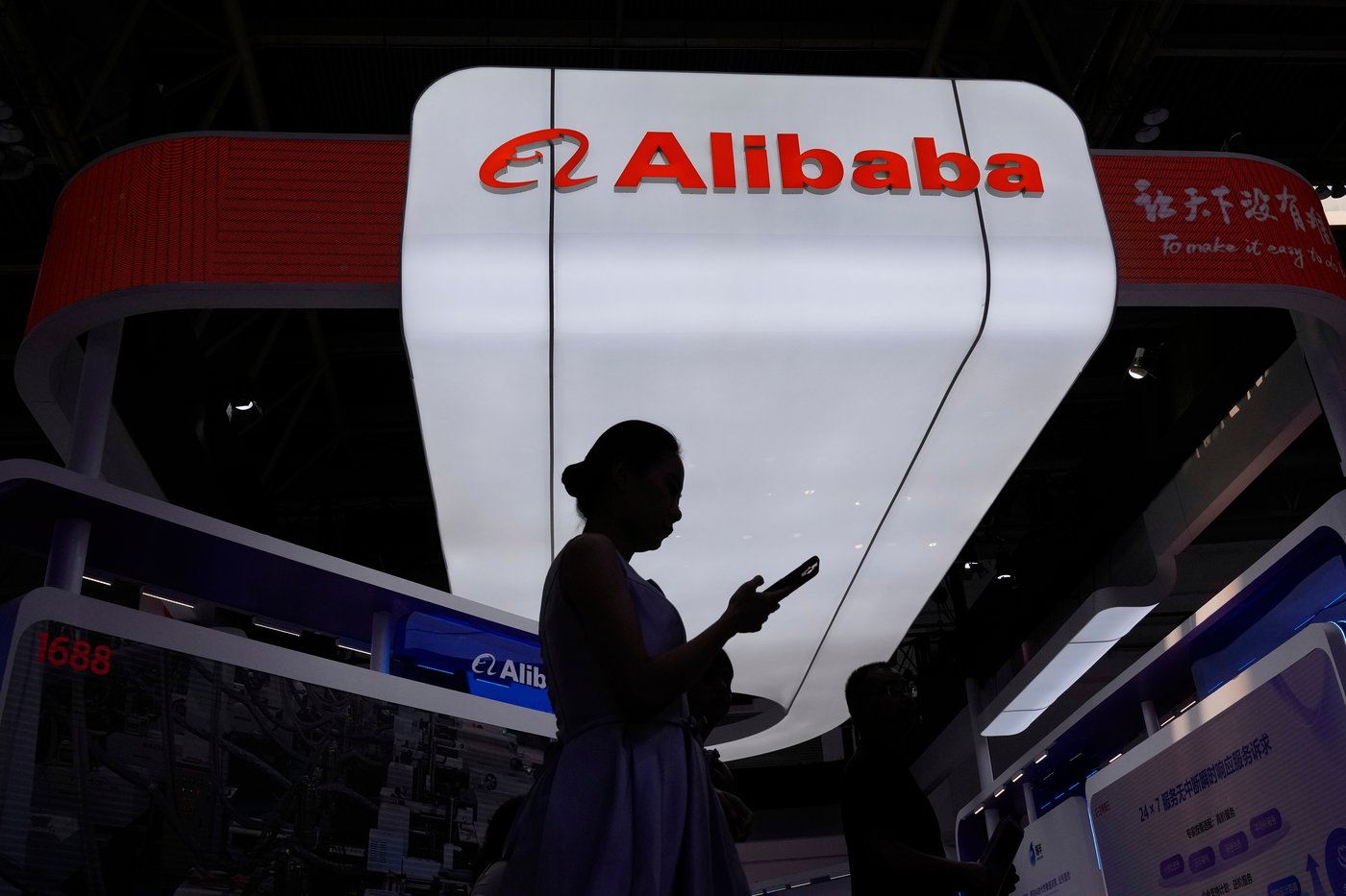 A visitor walks in front of Alibaba booth during the 3rd China International Supply Chain Expo at the China International Exhibition Center, in Beijing, China, Friday, July 18, 2025. (AP Photo/Mahesh Kumar A., file)