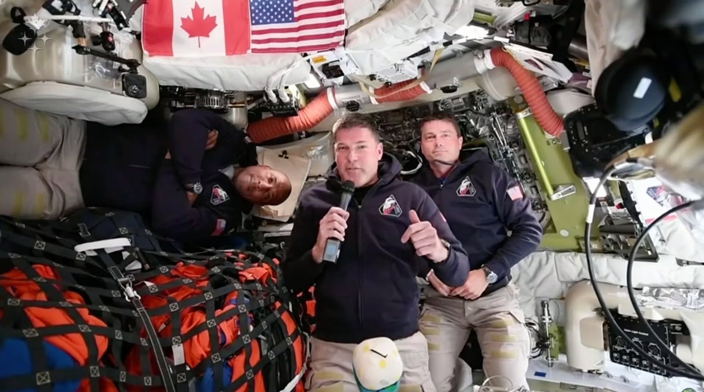 Artemis II astronaut Jeremy Hansen, of Canada, connects live from the Orion spacecraft and speaks with Canadian media along with NASA astronauts Victor Glover, left, and Reid Wiseman in a Saturday, April 4, 2026, handout photo. THE CANADIAN PRESS/AP — Handout, Canadian Space Agency (Mandatory Credit)