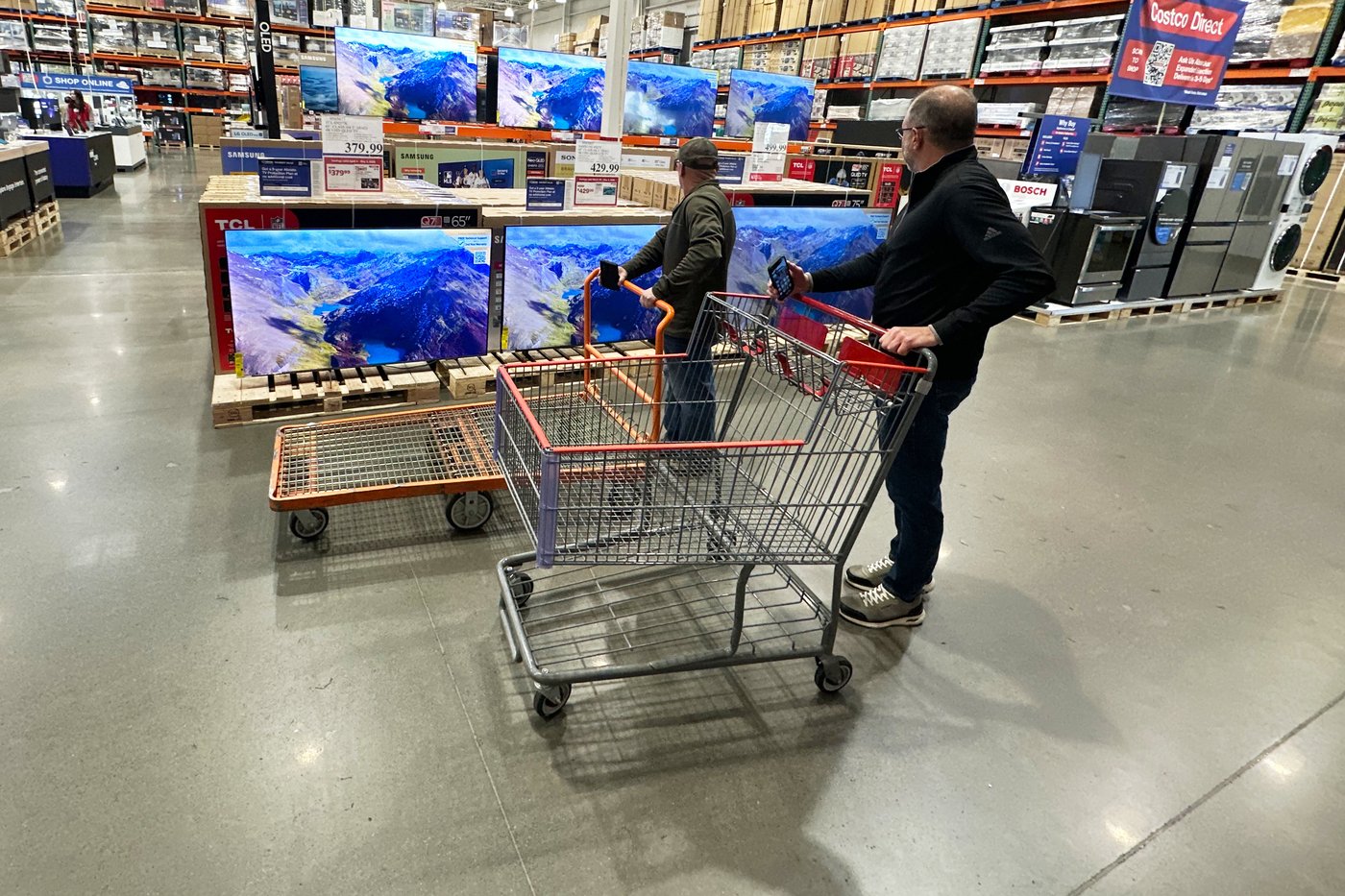 FILE - Shoppers stop their carts to observe big-screen televisions on display in a Costco warehouse Thursday, April 30, 2026, in Timnath, Colo. (AP Photo/David Zalubowski, File)
