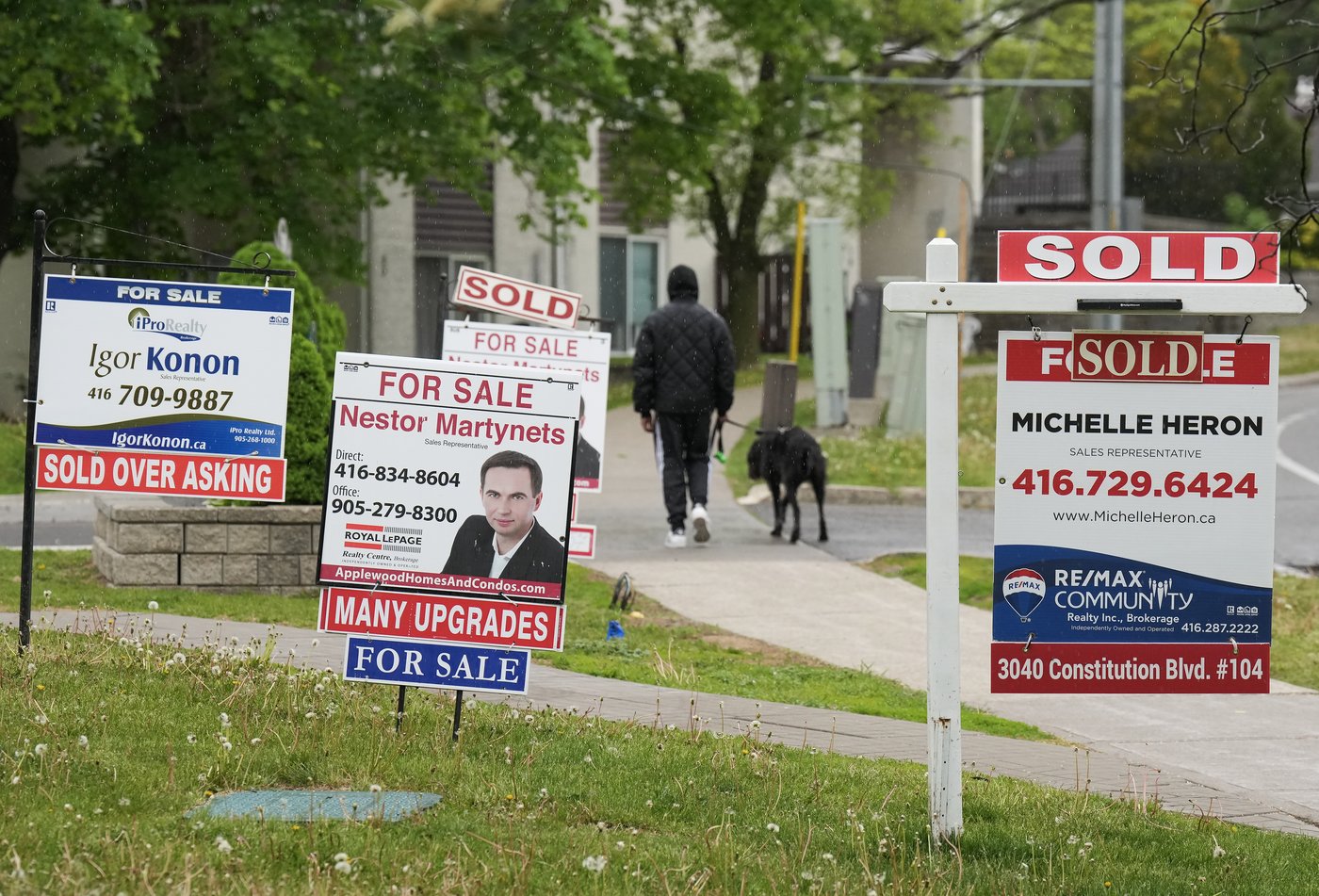 A person walks past multiple for-sale and sold real estate signs in Mississauga, Ont., on Wednesday, May 24, 2023. THE CANADIAN PRESS/Nathan Denette