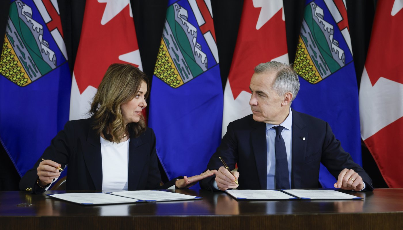 Prime Minister Mark Carney, right, signs an MOU with Alberta Premier Danielle Smith in Calgary, Alta., Thursday, Nov. 27, 2025. THE CANADIAN PRESS/Jeff McIntosh