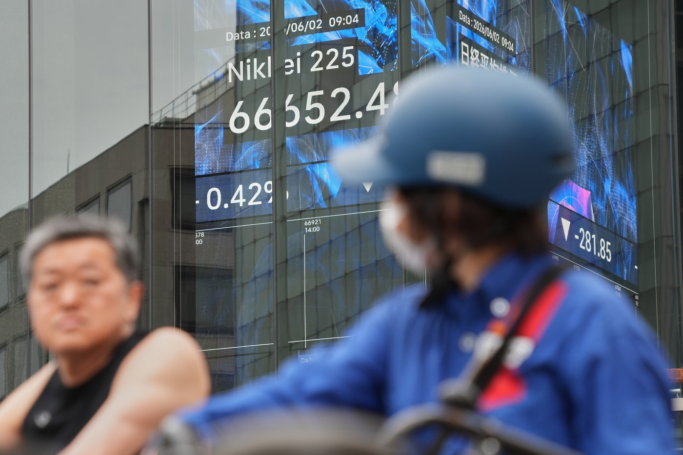 People stop in front of an electronic stock board showing Japan's Nikkei index at a securities firm Tuesday, June 2, 2026, in Tokyo. (AP Photo/Eugene Hoshiko)
