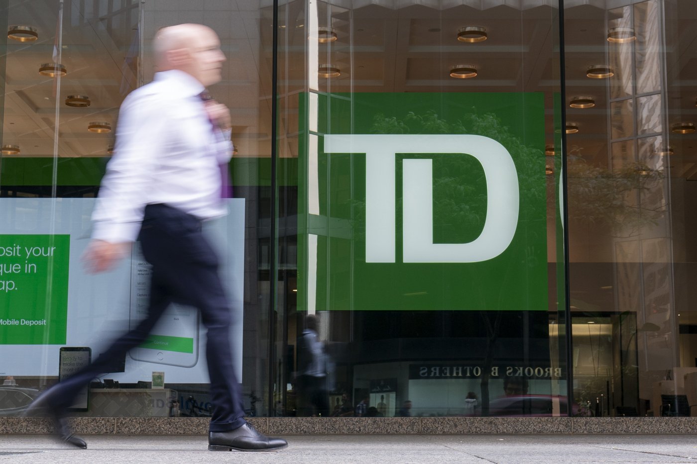 A person makes their way past a Toronto-Dominion Bank in the Financial District of Toronto, Monday, Aug. 14, 2023. THE CANADIAN PRESS/Spencer Colby