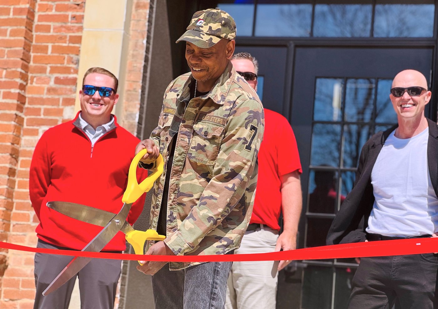 Comedian Dave Chappelle, center, takes part in a ribbon-cutting ceremony for a new studio for WYSO Public Radio at a building in Yellow Springs, Ohio, on Thursday, April 9, 2026. (AP Photo/Jonathan Landrum)