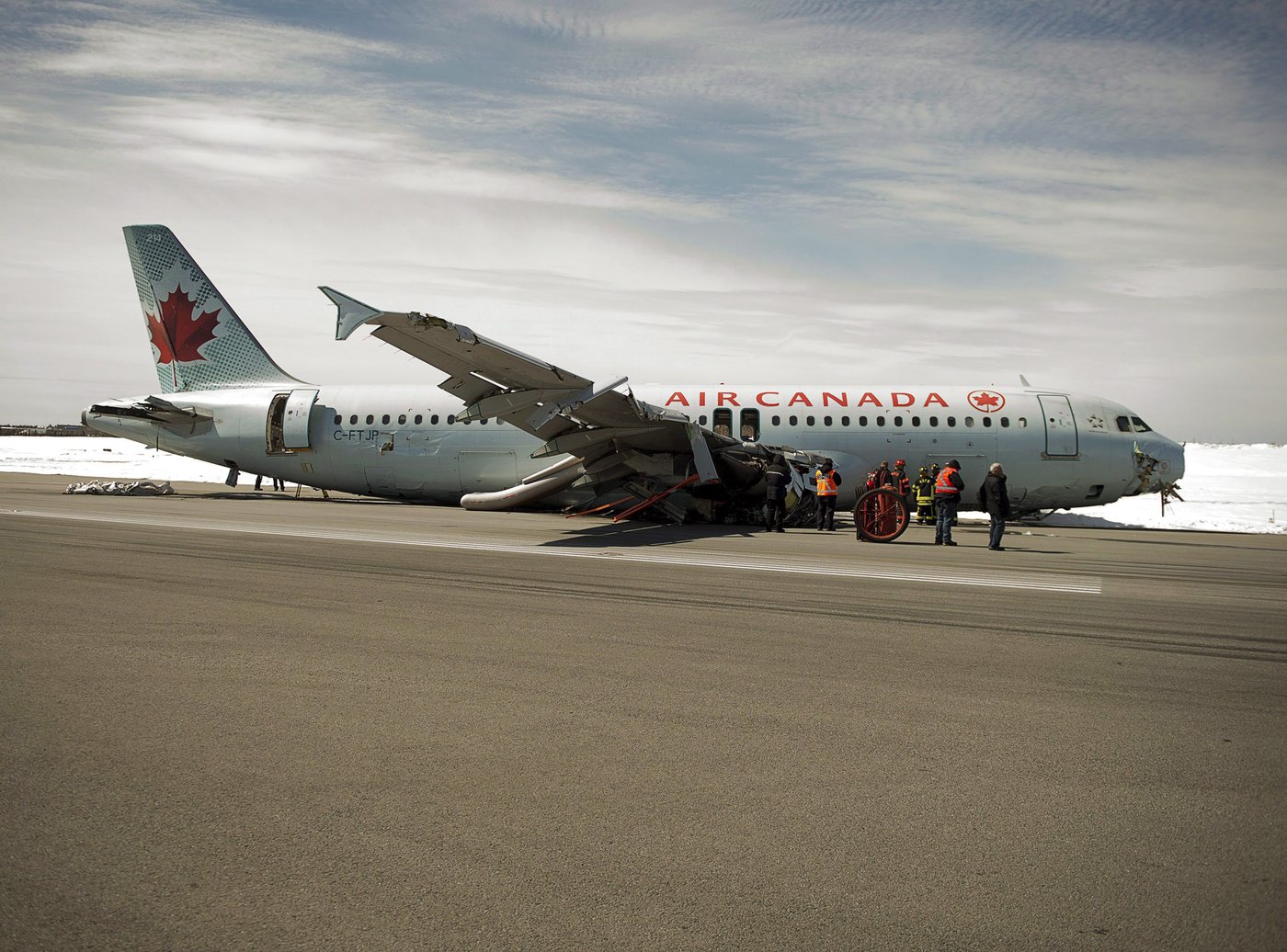 Transportation Safety Board investigators and airport firefighters work at the crash site of Air Canada AC624 that crashed early Sunday morning during a snowstorm, at Stanfield International Airport in Halifax on Monday, March 30, 2015. THE CANADIAN PRESS/Andrew Vaughan