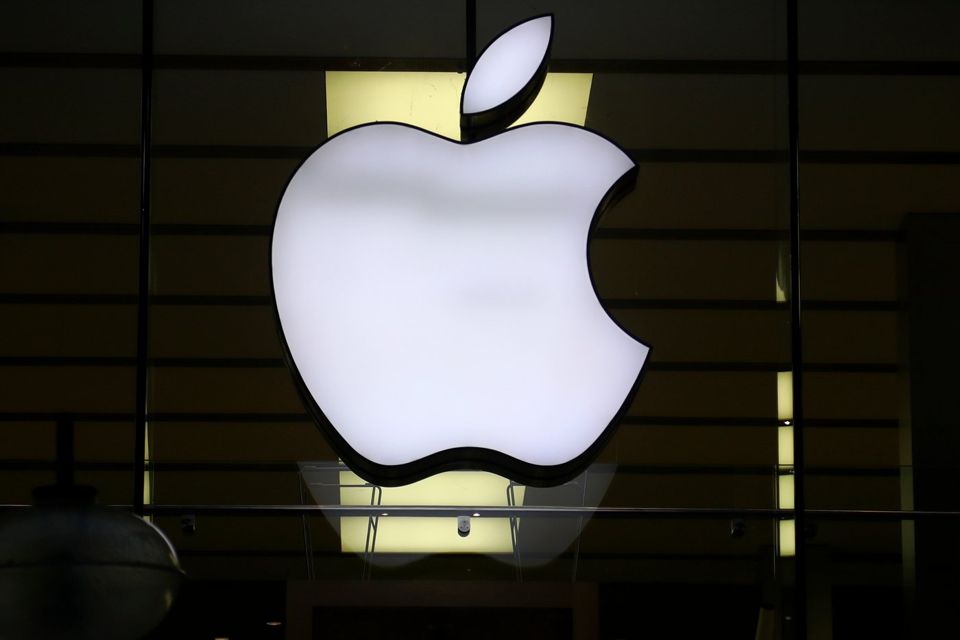 FILE - The logo of Apple is illuminated at a store in the city center in Munich, Germany, on Dec. 16, 2020. (AP Photo/Matthias Schrader, File)