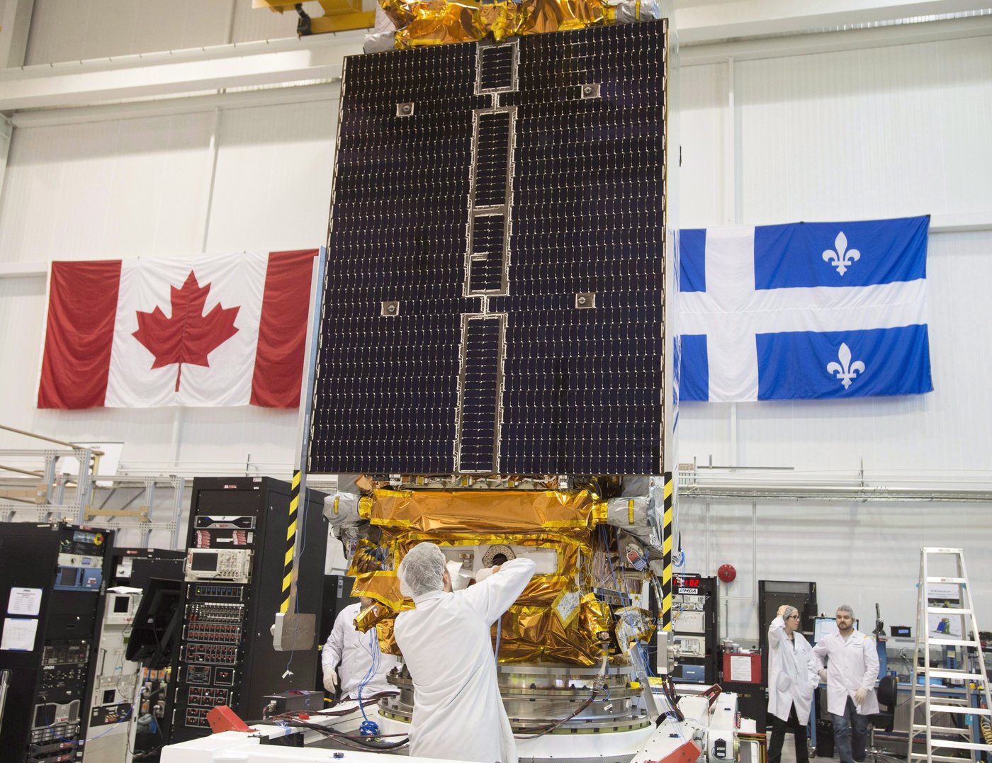 Technicians put the final touches on the second of three Radarsat Constellation Mission satellites at the MDA facility Thursday, June 21, 2018 in Montreal. THE CANADIAN PRESS/Ryan Remiorz