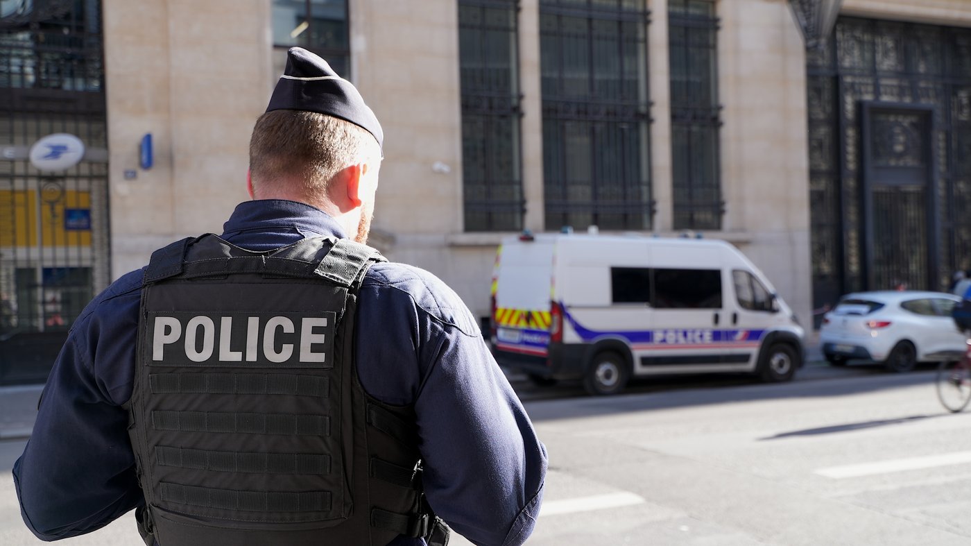 Police stand outside the Bank of America building in Paris, Saturday, March 28, 2026. (AP Photo/Nicolas Garriga)