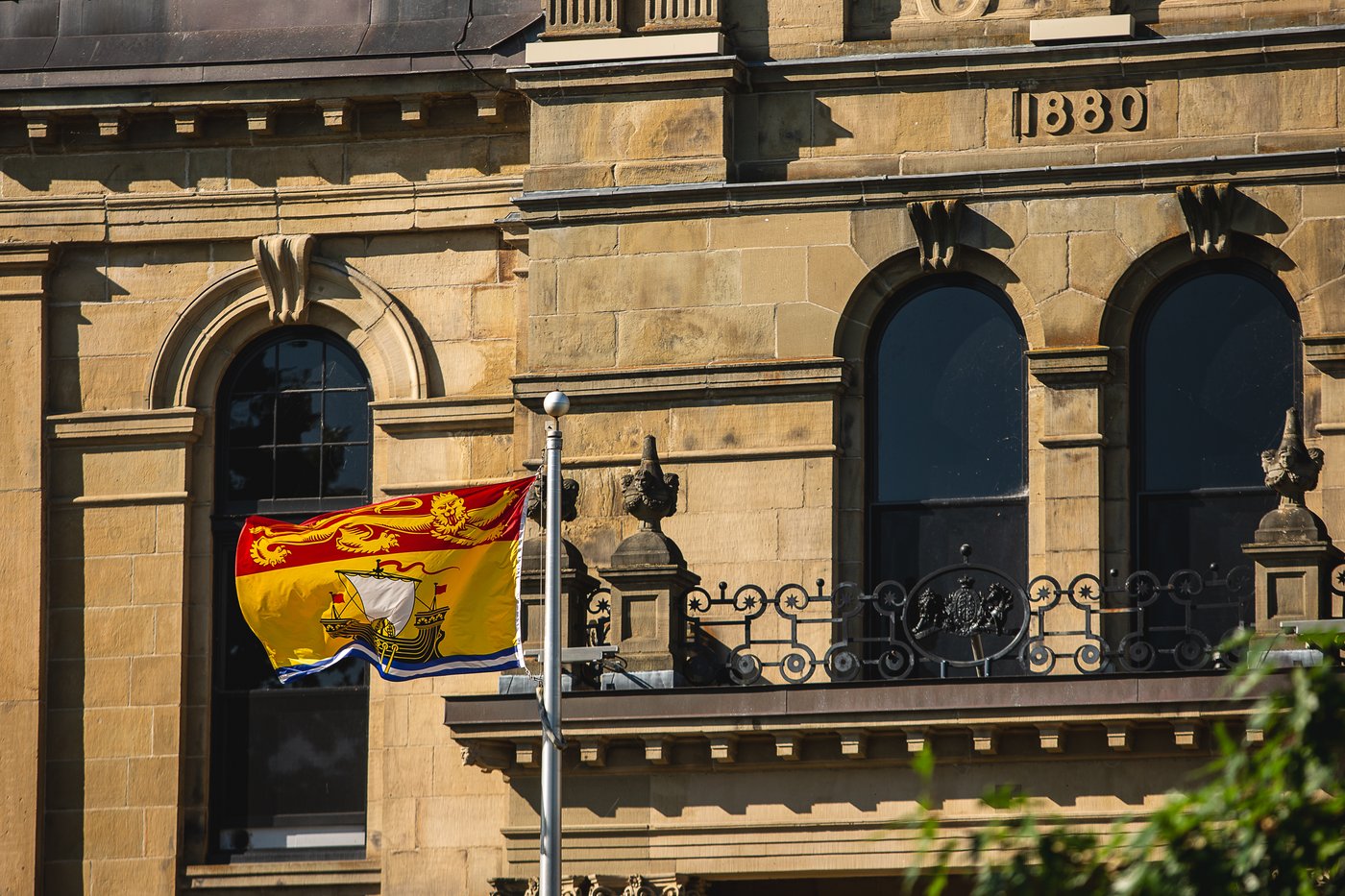 The New Brunswick flag flies in front of the legislative assembly building, home of the provincial parliament, in Fredericton, Saturday, July 26, 2025. THE CANADIAN PRESS/Giordano Ciampini
