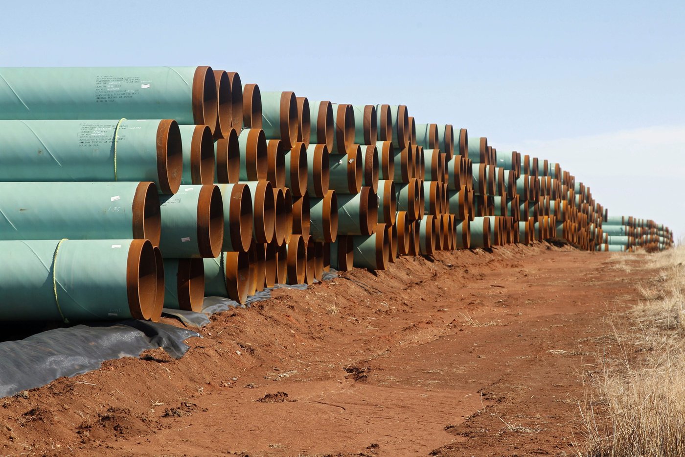 In this Feb. 1, 2012 file photo, miles of pipe for the stalled Canada-to-Texas Keystone XL pipeline are stacked in a field near Ripley, Okla. (AP Photo/Sue Ogrocki, File)