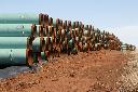 In this Feb. 1, 2012 file photo, miles of pipe for the stalled Canada-to-Texas Keystone XL pipeline are stacked in a field near Ripley, Okla. (AP Photo/Sue Ogrocki, File)