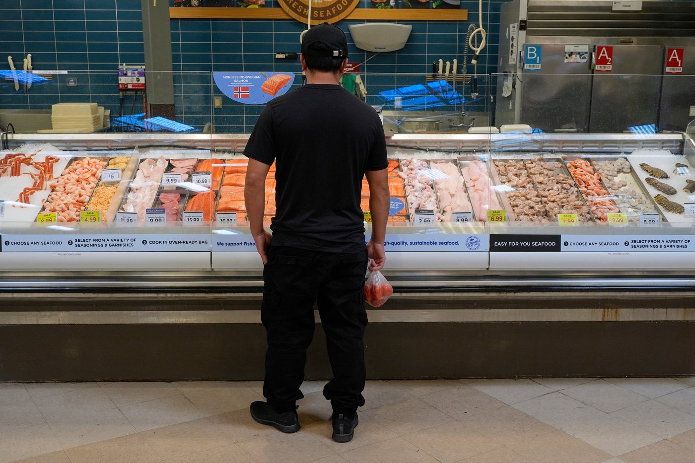 A person looks at the fresh fish at a grocery store Monday, May 11, 2026, in Nashville, Tenn. (AP Photo/George Walker IV)