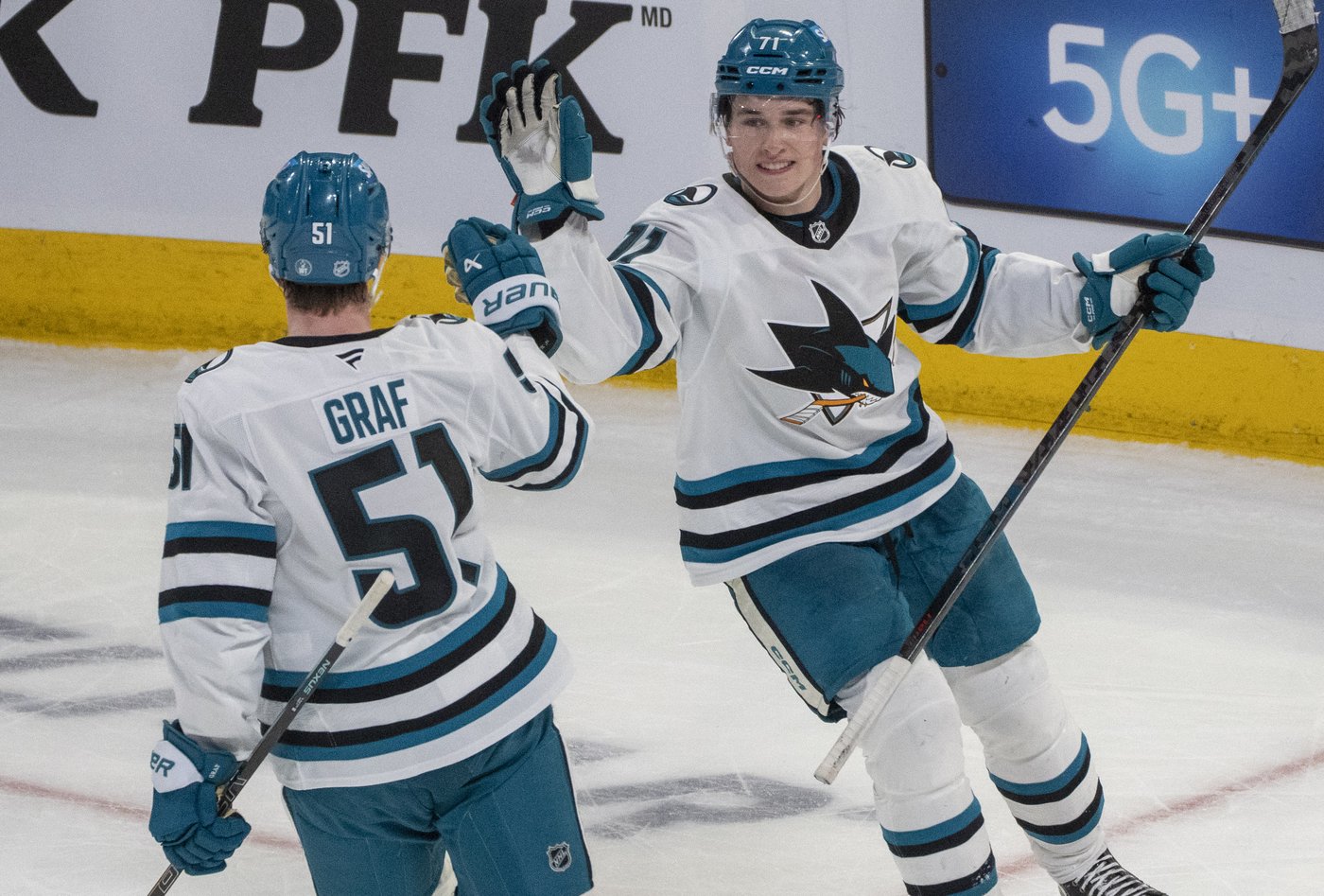 San Jose Sharks centre Macklin Celebrini (71) celebrates his empty net goal with teammate Collin Graf (51) against the Canadiens in Montreal on Saturday, March 14, 2026. THE CANADIAN PRESS/Christinne Muschi