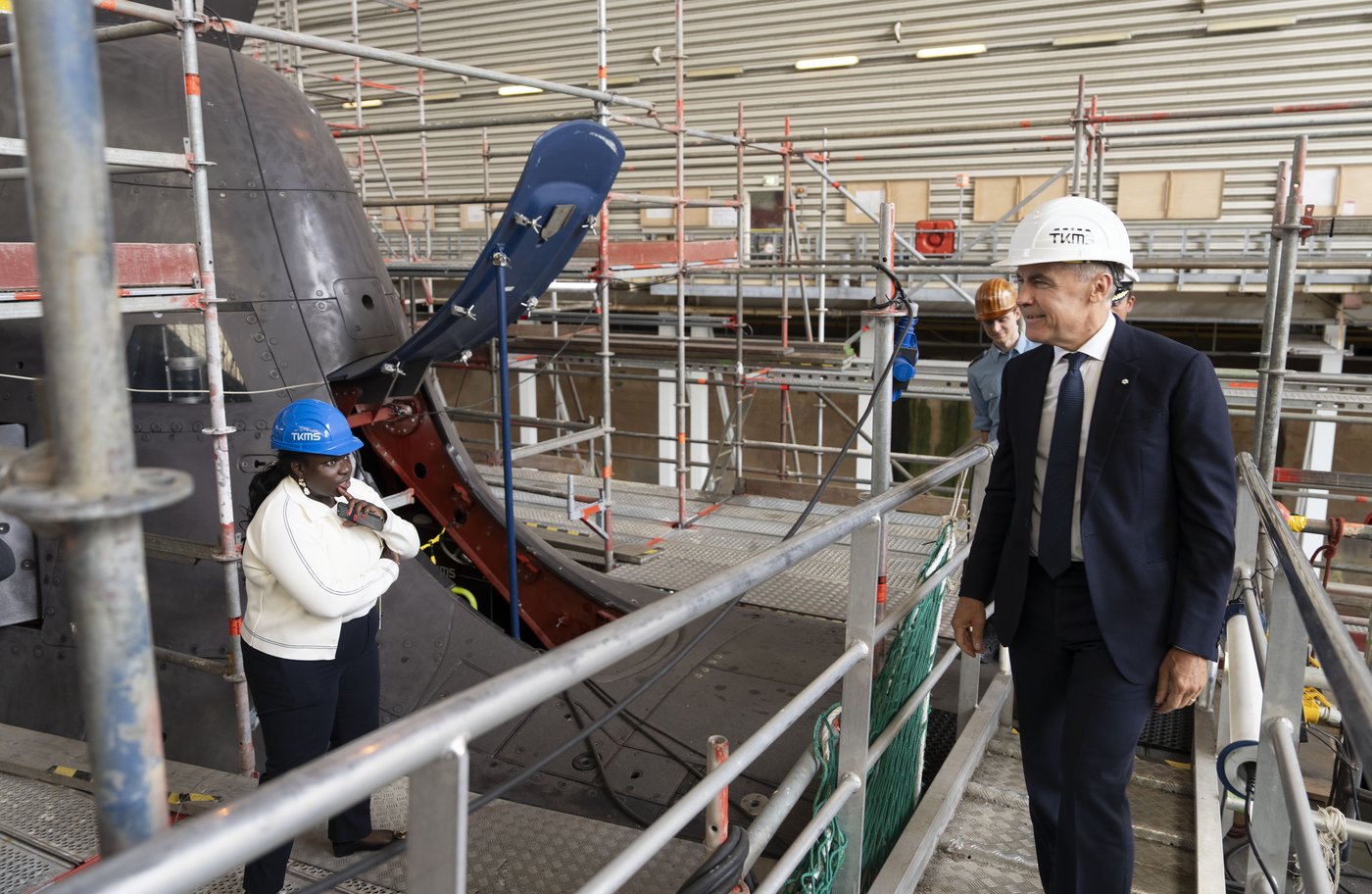 File photo -- Prime Minister Mark Carney looks over a 212A class submarine under maintenance as he tours Thyssenkrupp Marine Systems (TKMS), a submarine building facility in Kiel, Germany on Tuesday, Aug. 26, 2025. THE CANADIAN PRESS/Christinne Muschi