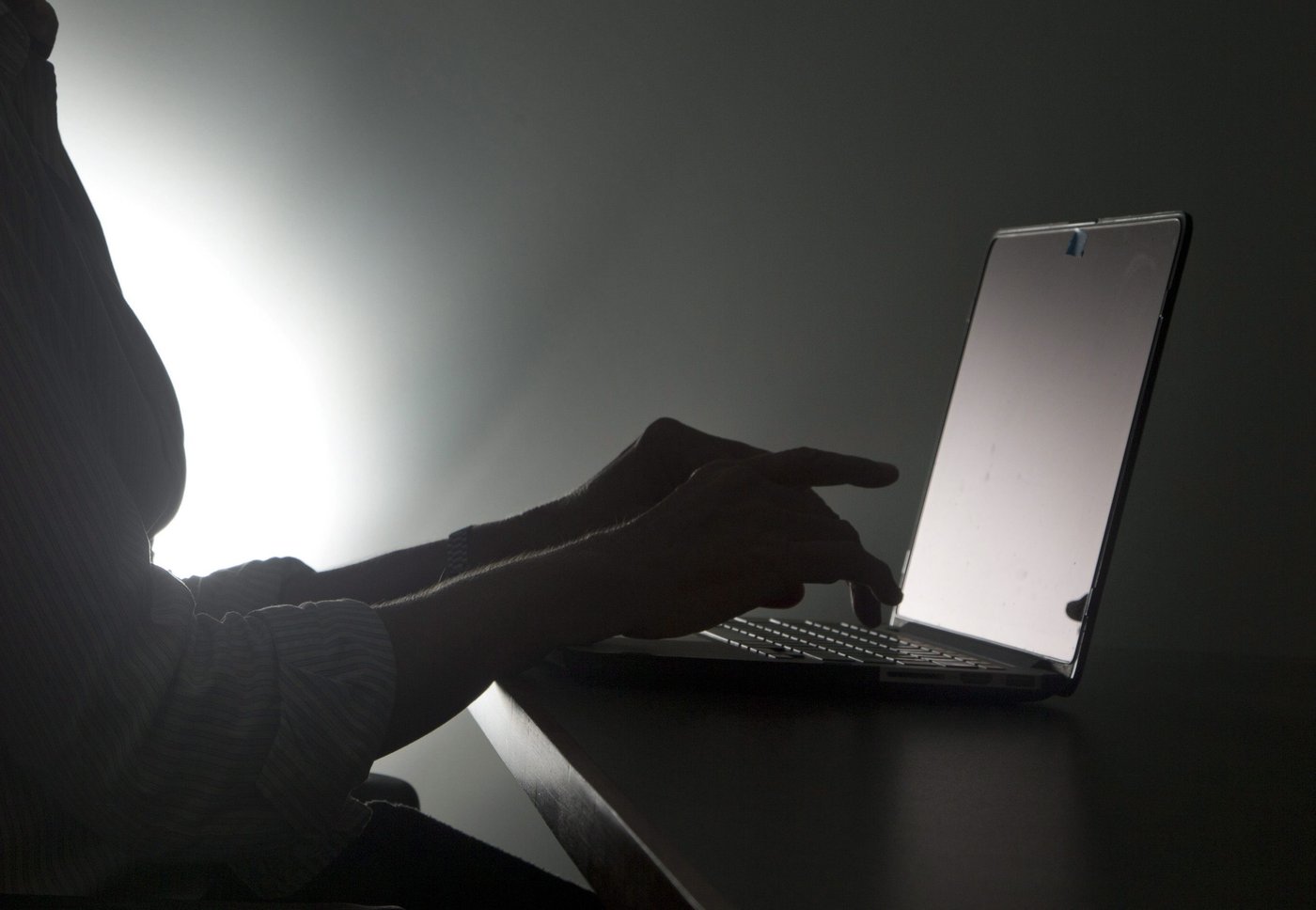 A person types on a laptop in Florida in a Dec. 12, 2016, photo illustration. THE CANADIAN PRESS/AP-Wilfredo Lee