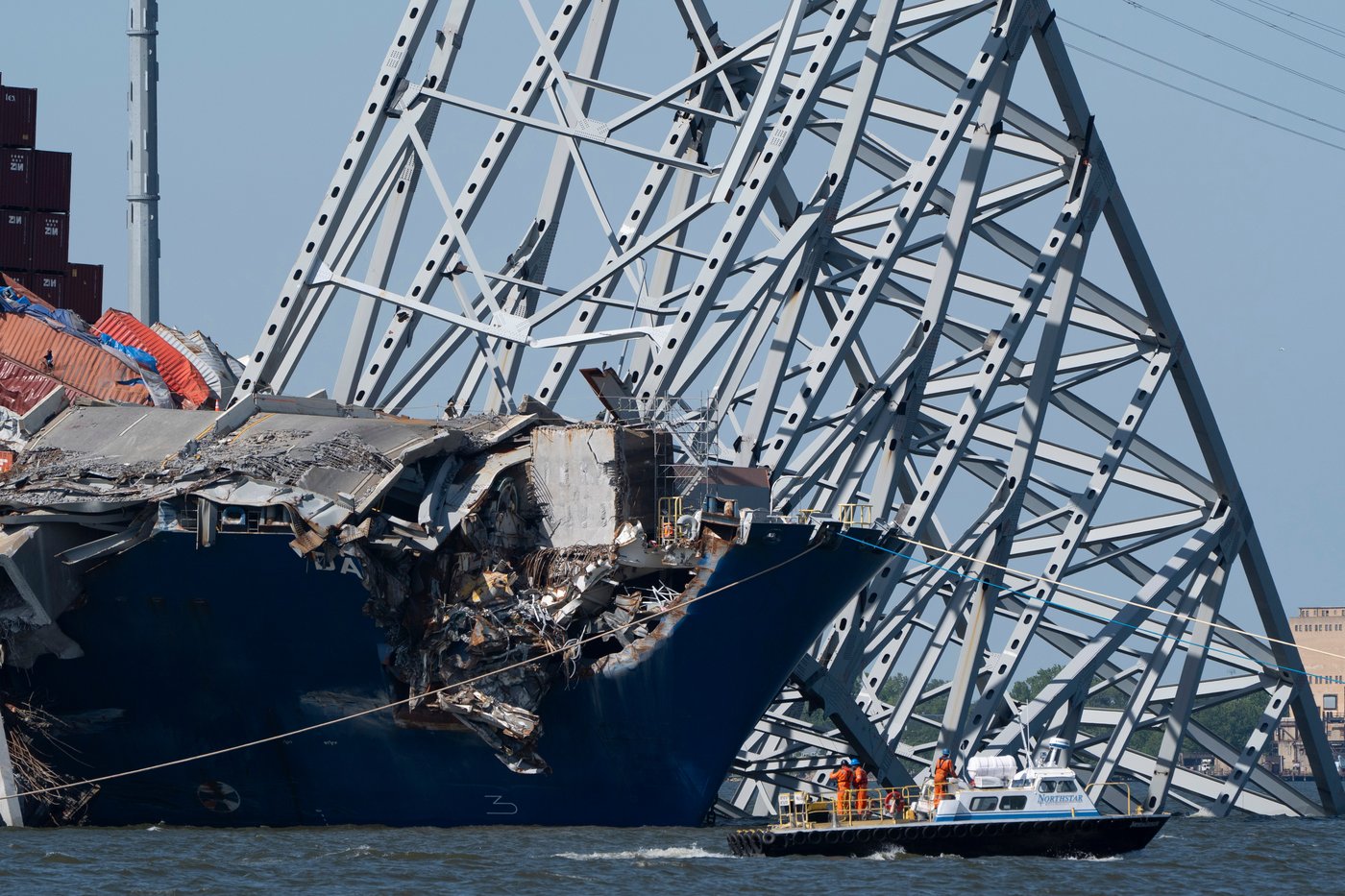 FILE - A boat moves past the bow of the container ship Dali prior to the detonation of explosive charges to bring down sections of the collapsed Francis Scott Key Bridge resting on the Dali, May 13, 2024, in Baltimore. (AP Photo/Mark Schiefelbein,File)