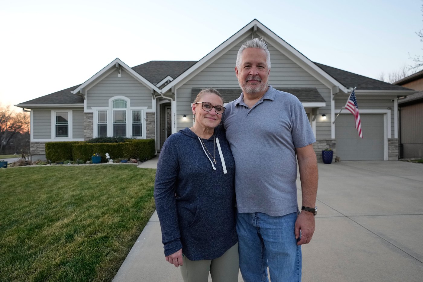 Gail and David Sanders stand in front of their home which they have been trying to sell Wednesday, March 25, 2026, in Olathe, Kan. (AP Photo/Charlie Riedel)