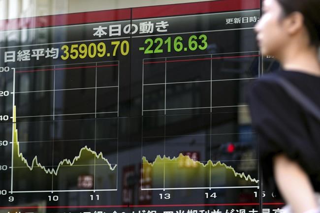 A person walks in front of an electronic stock board showing Japan's Nikkei 225 index Friday, Aug. 2, 2024, in Tokyo. Shares in Europe and Asia tumbled Friday, with Japan’s Nikkei 225 index slumping 5.8% as investors panicked over signs of weakness in the U.S. economy. (Kyodo News via AP)