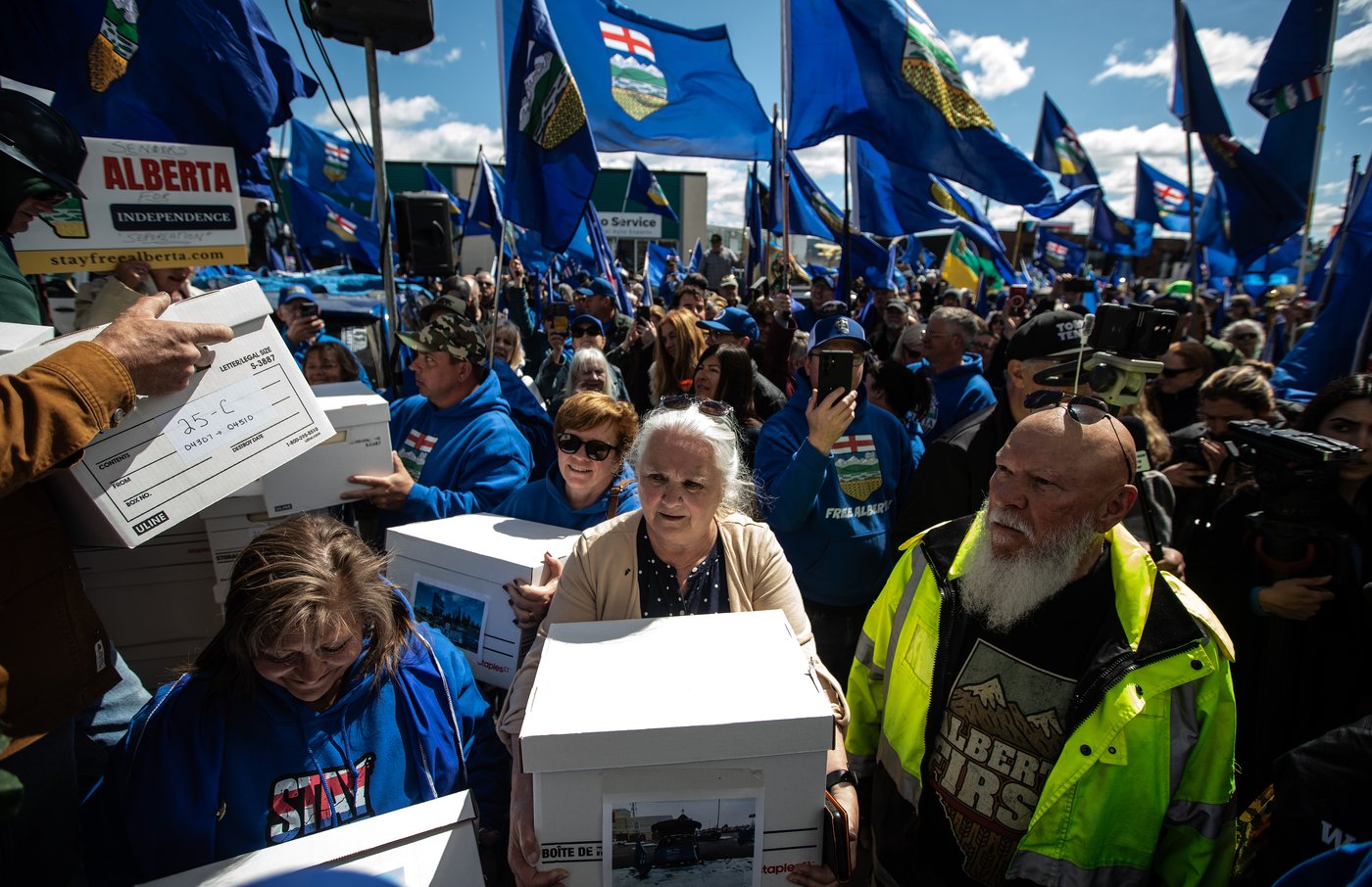 Supporters carry boxes of signatures to submit for a separation referendum to Elections Alberta in Edmonton, on Monday, May 4, 2026. THE CANADIAN PRESS/Jason Franson