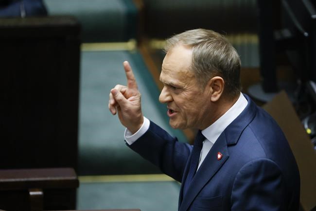 Donald Tusk speaks to lawmaker after he was elected as Poland's Prime Minister at the parliament in Warsaw, Poland, Monday Dec. 11, 2023. (AP Photo/Michal Dyjuk)