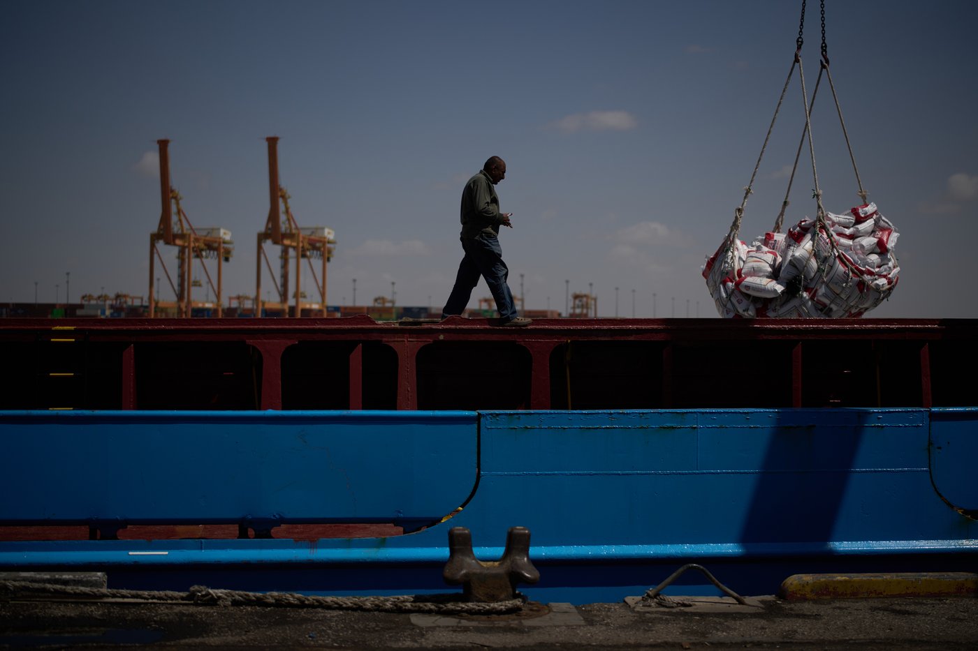 A worker walks on the deck of a feeder vessel as he works to offload cargo of rice into trucks at Umm Qasr Port, a deep-water port, in the city of Umm Qasr, Iraq, Friday, March 27, 2026. (AP Photo/Leo Correa)