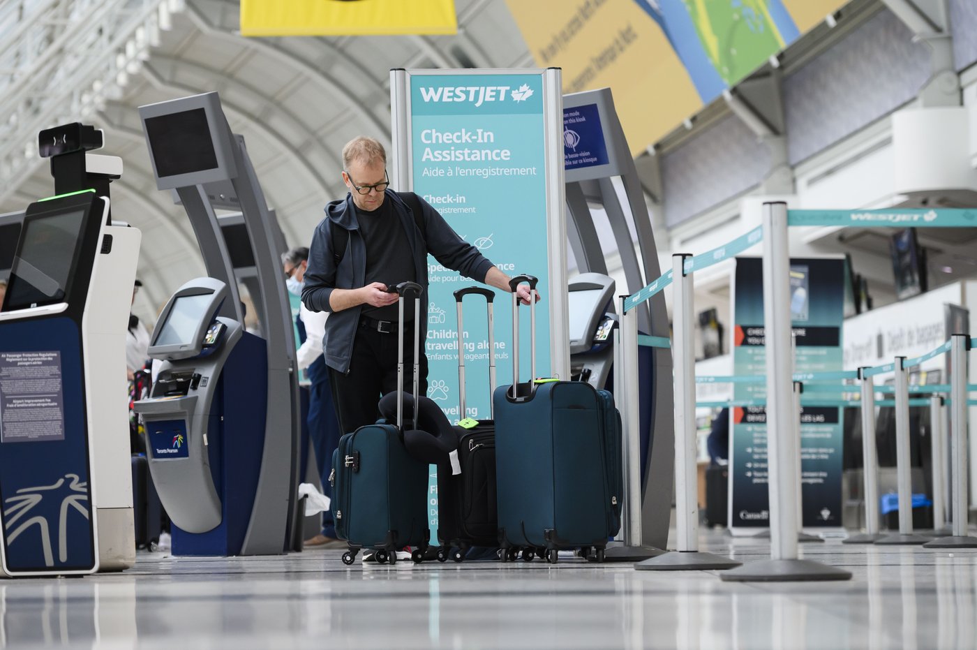Passengers are seen in the WestJet check-in area at Pearson International Airport, in Toronto, Saturday, June 29, 2024. THE CANADIAN PRESS/Christopher Katsarov”