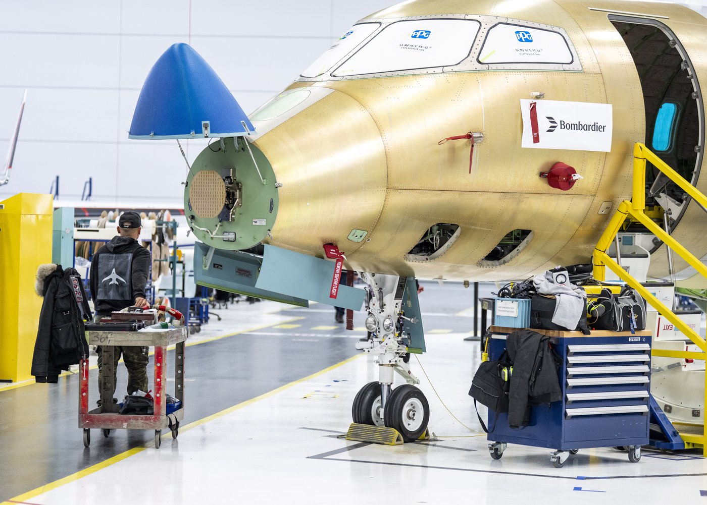 A Bombardier walks past a Challenger jet at their manufacturing facilities in Dorval, Que., on Thursday, Jan. 15, 2026. THE CANADIAN PRESS/Christinne Muschi