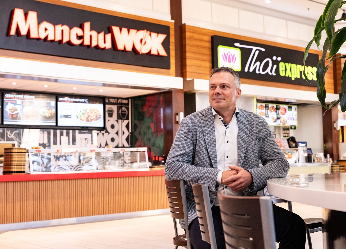 Eric Lefebvre, CEO of MTY Food Group Inc., a Canadian franchisor and operator of numerous casual dining and quick service restaurants poses in front of two of their food court brands, Manchu Wok and Thai Express, in Montreal, Monday, Dec. 2, 2024. THE CANADIAN PRESS/Christinne Muschi