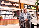 Eric Lefebvre, CEO of MTY Food Group Inc., a Canadian franchisor and operator of numerous casual dining and quick service restaurants poses in front of two of their food court brands, Manchu Wok and Thai Express, in Montreal, Monday, Dec. 2, 2024. THE CANADIAN PRESS/Christinne Muschi