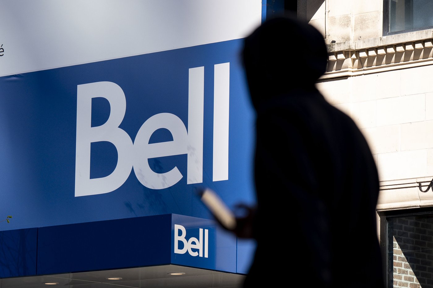 People walk bast a Bell store in downtown Montreal on Wednesday, May 7, 2025. THE CANADIAN PRESS/Christopher Katsarov