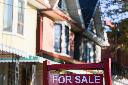 A real estate sign is displayed in front of a house in the Riverdale area of Toronto on Wednesday, Sept. 29, 2021. THE CANADIAN PRESS/Evan Buhler