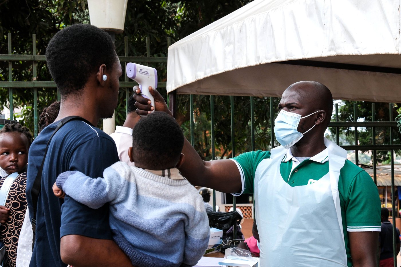 A health official uses a thermometer to screen people in front of Kibuli Muslim Hospital in Kampala, Uganda, Saturday, May 16, 2026. (AP Photo/ Hajarah Nalwadda)